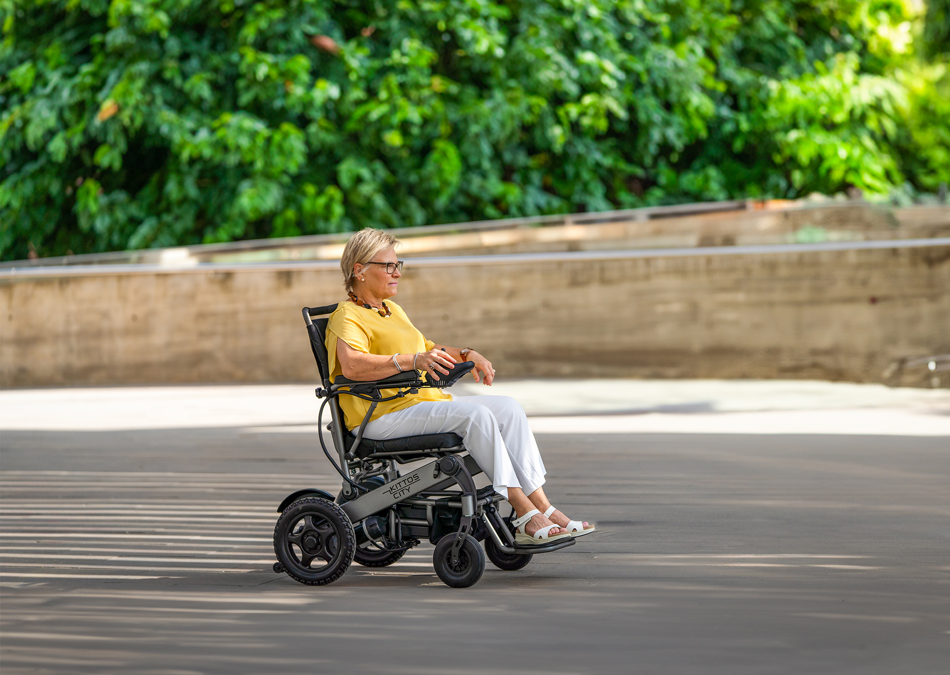 Mujer paseando con su silla de ruedas eléctrica Kittos City
